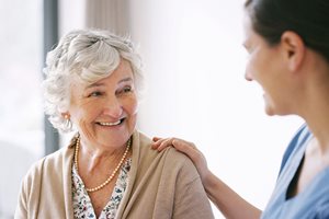 A hearing expert from Connect hearing puts a hand on the shoulder of a patient for encouragement.