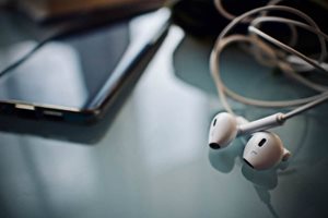 Headphones next to a mobile device.